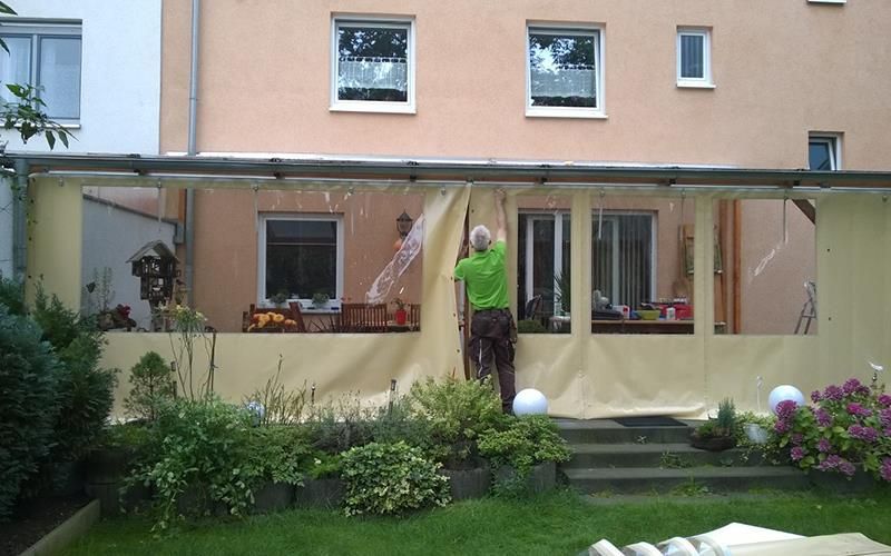 Ein Mann in einem grünen Hemd steht vor einem Gebäude