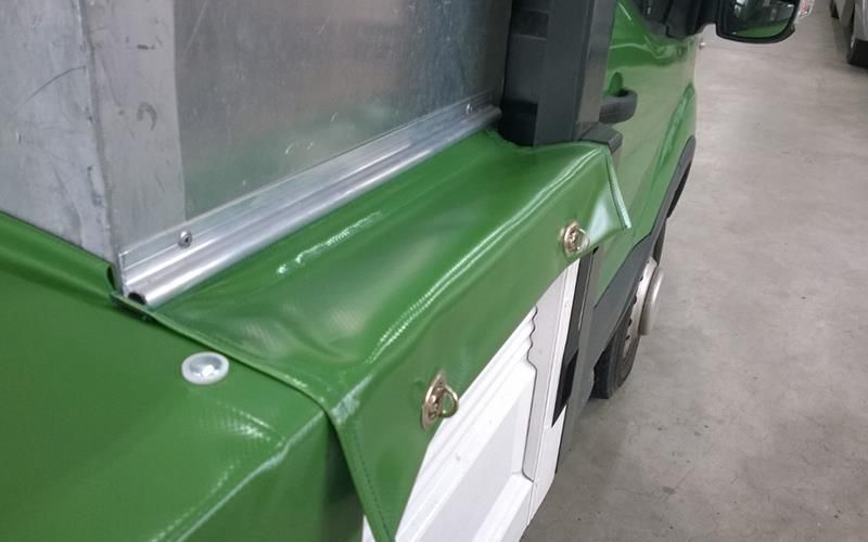 Ein grüner Gabelstapler steht in einer Garage.