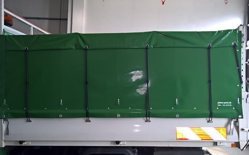 Eine grüne Plane bedeckt die Ladefläche eines Lastwagens