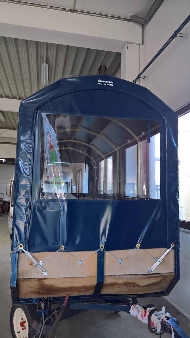 Ein blauer Kombi steht in einer Garage neben einem Fenster.