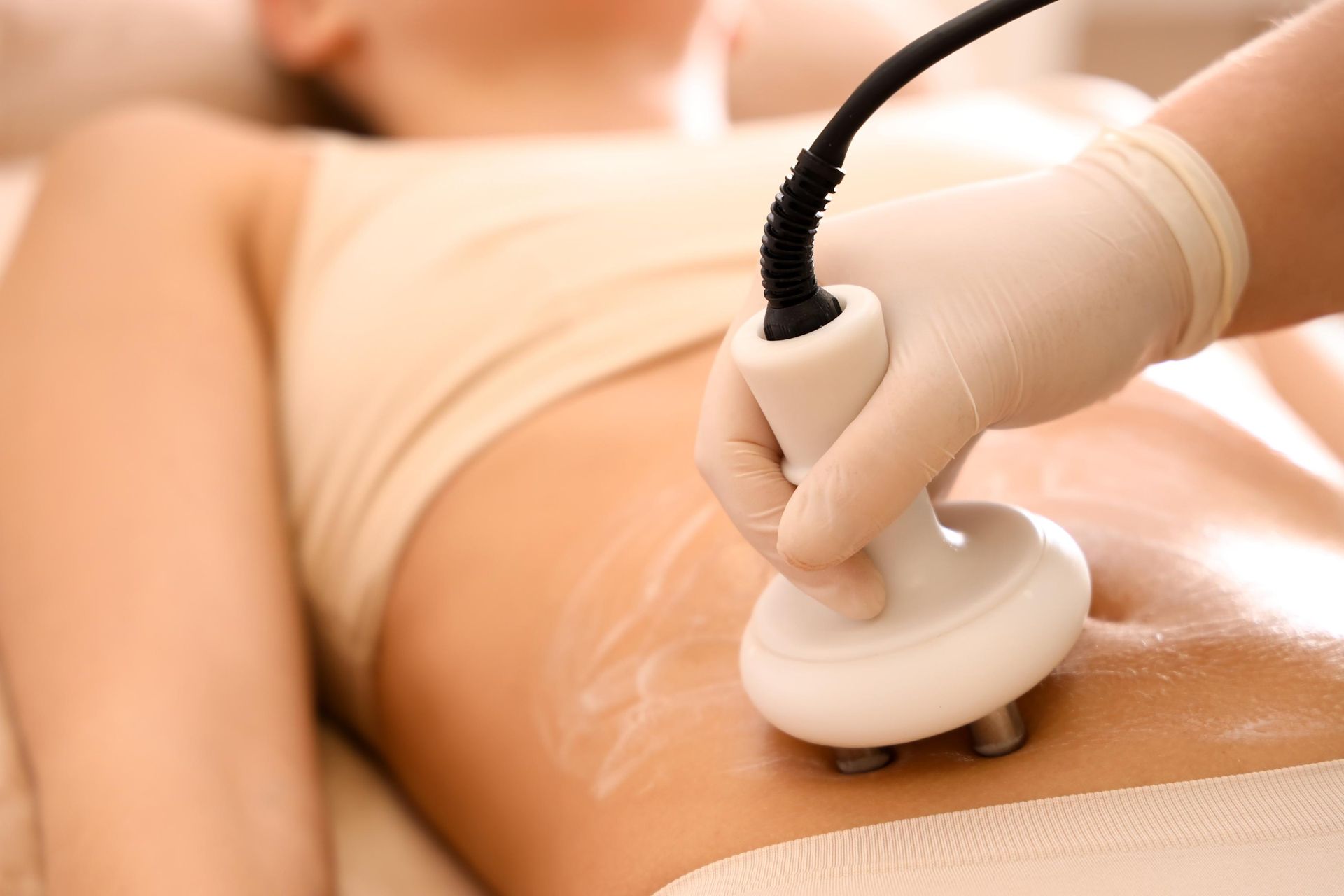 Eine Frau bekommt eine Kavitationsbehandlung am Bauch.