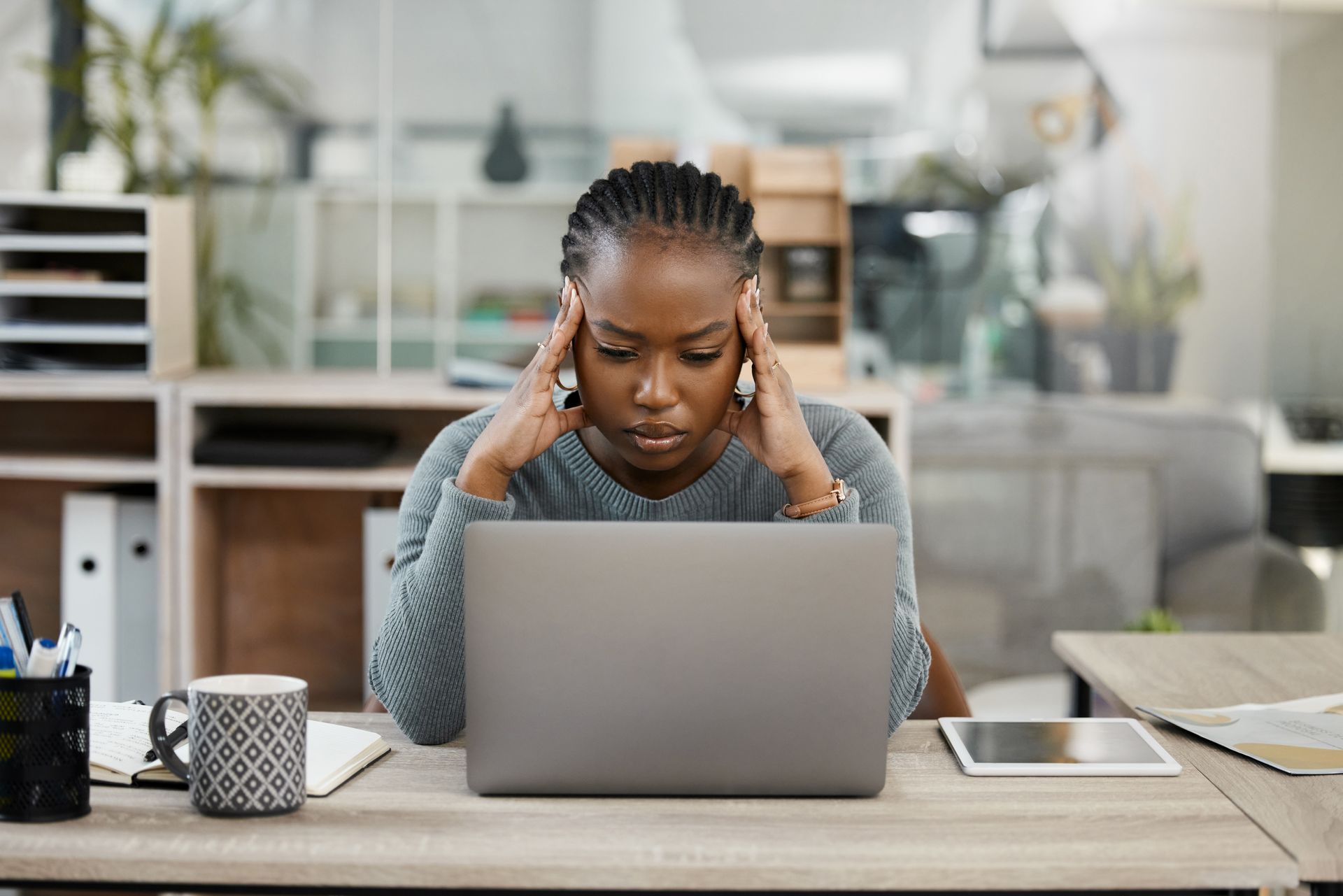 Femme pensive devant son ordinateur de travail