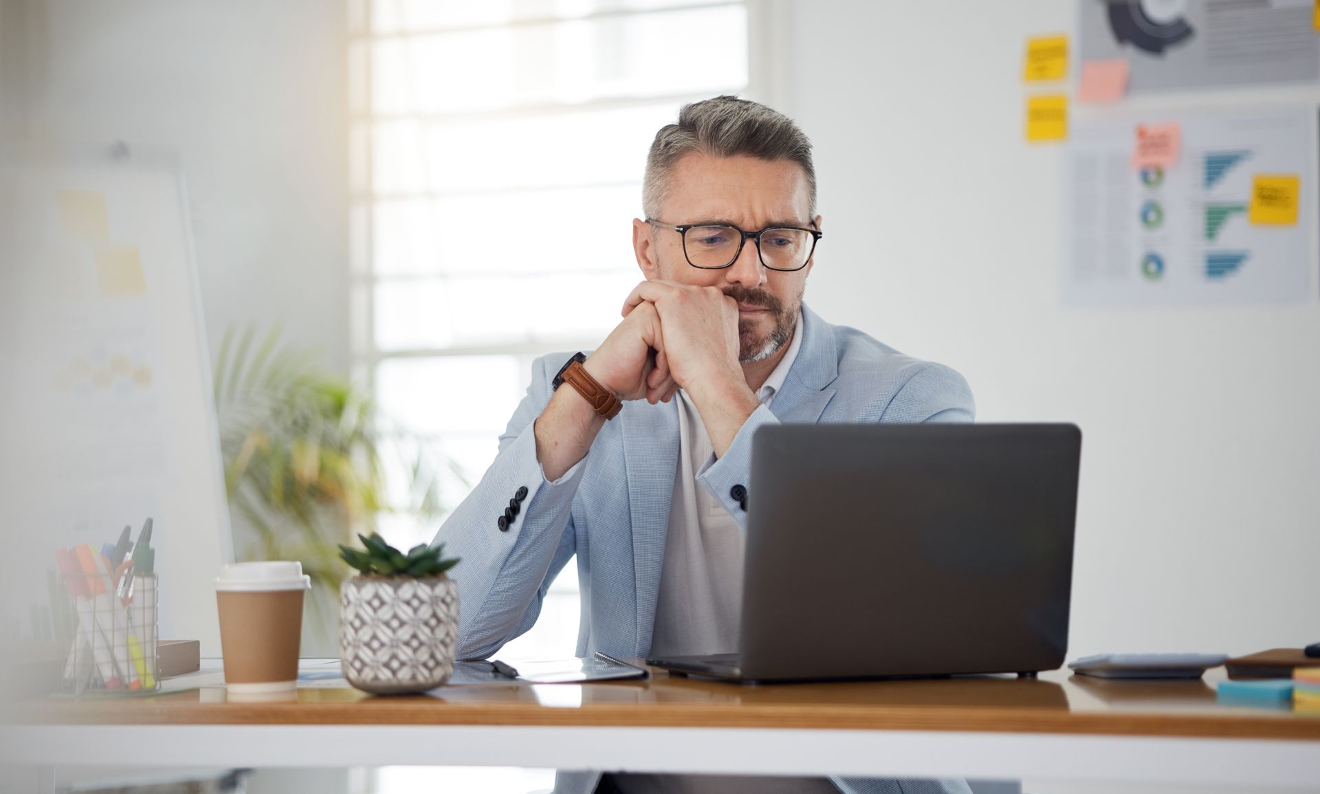 Homme pensif devant son ordinateur de travail