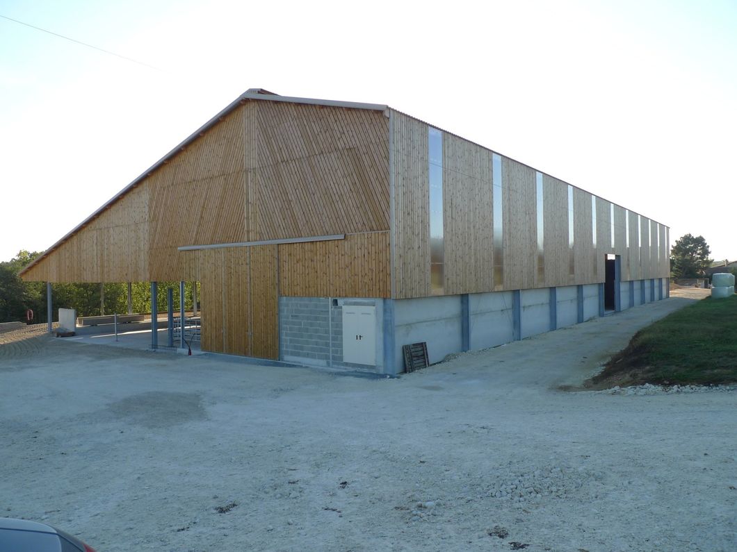 Grange en bois avec toit en pente et fondation en béton