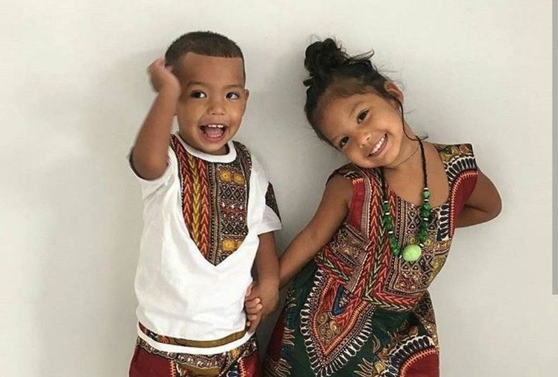 Un garçon et une fille avec des tenues assorties avec des motifs ethniques.