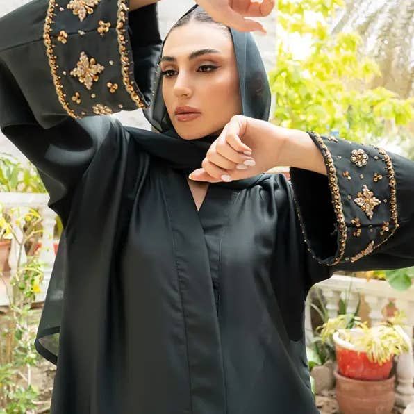 Abaya noire avec broderie de perles sur les manches.