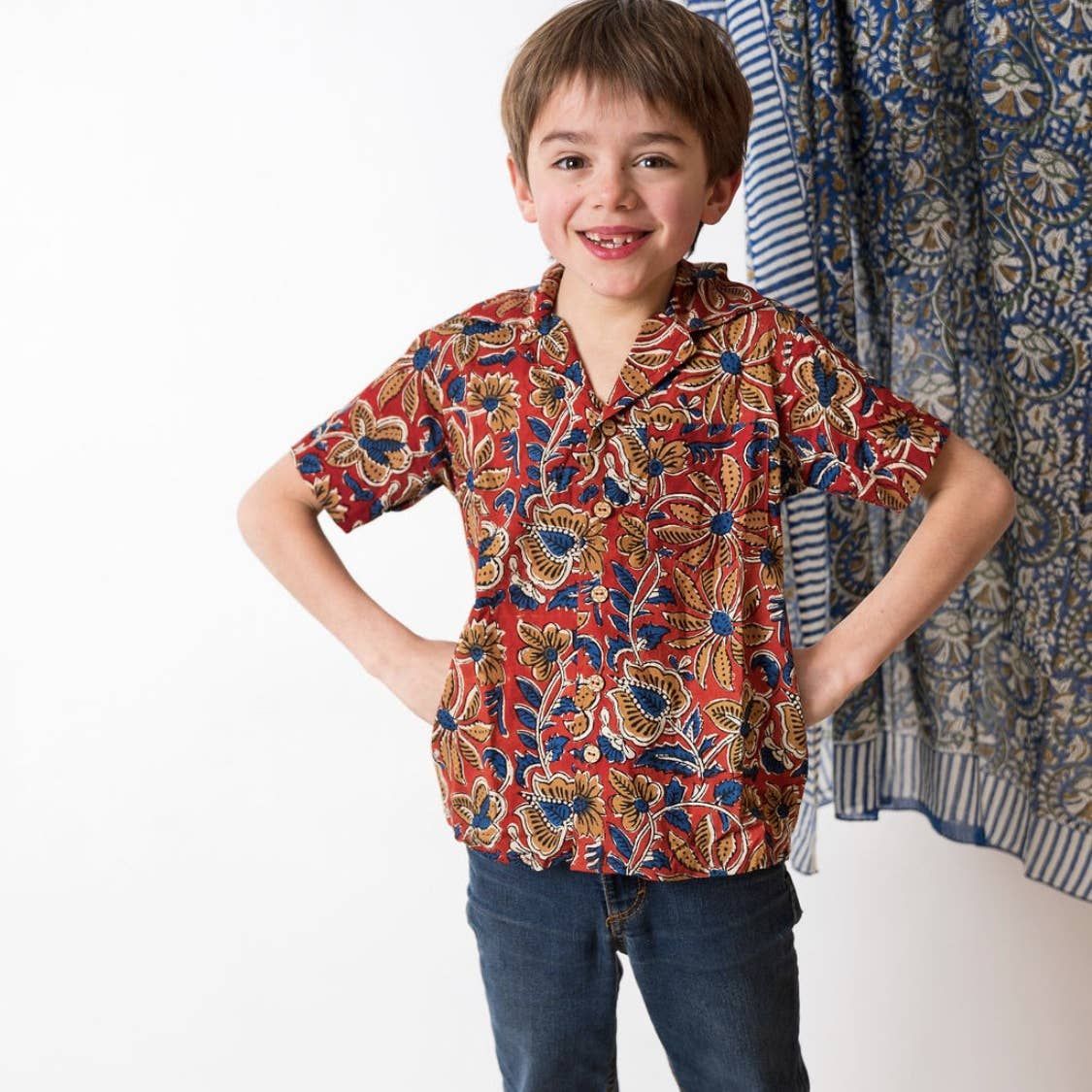 Petit garçon avec une chemise à manches courtes à motif ethnique.