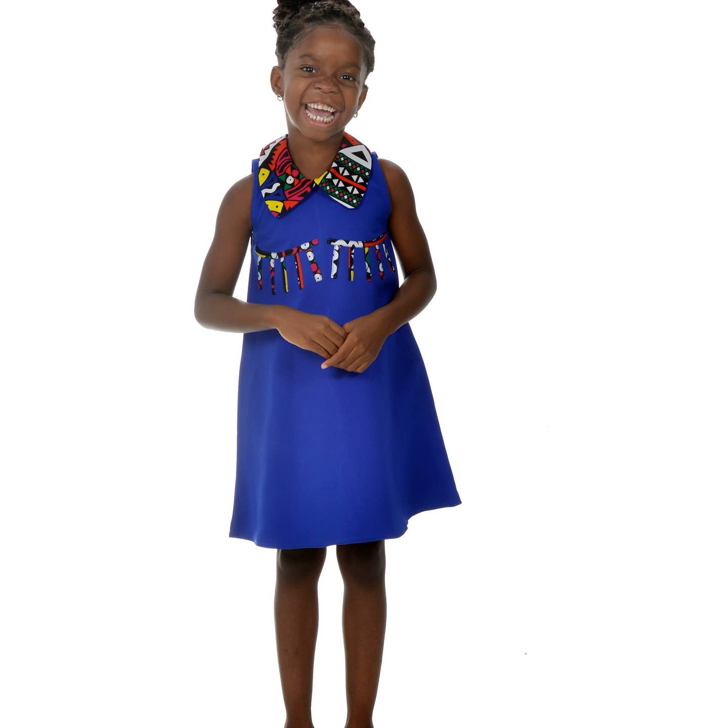 Fillette avec robe bleu à col en wax.