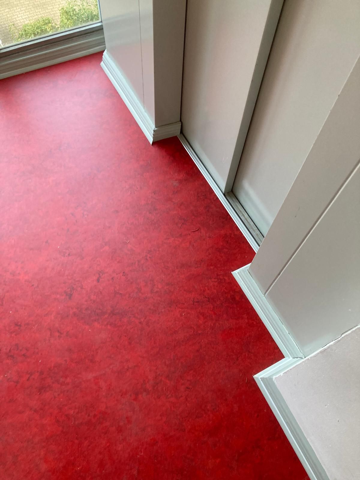 Linoleumbelag angearbeitet an Fahrstuhl und Sockelleisten