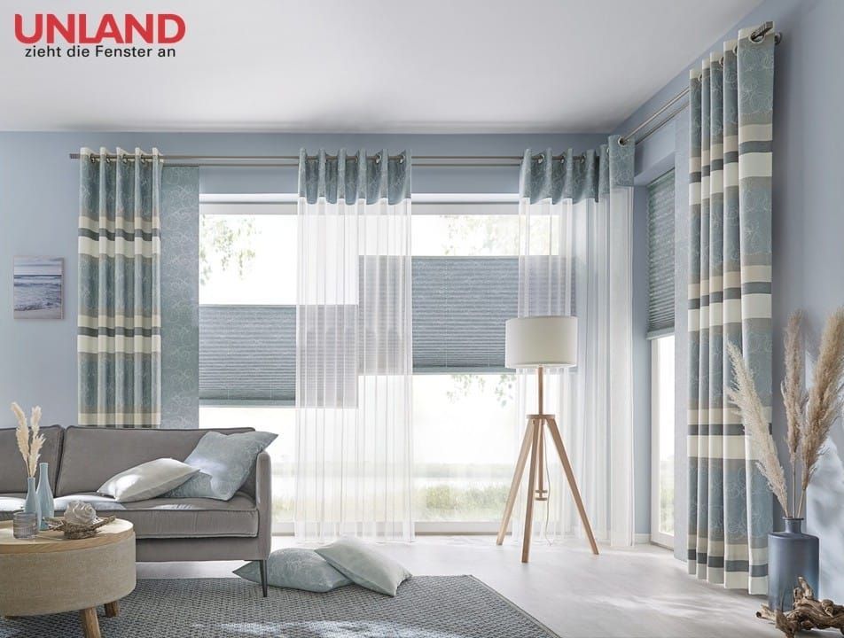 Wohnzimmer mit grauen Gardinen und einer Stehlampe