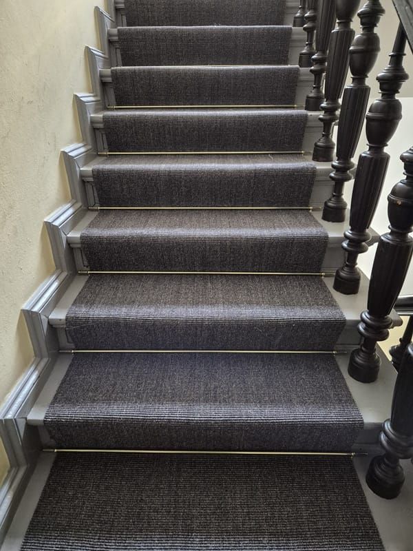Treppenlauf mit grauem Sisal und vernickelten Läuferstangen