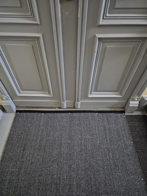 Sisalbelag mit Türabschluss un schwarzer Bandeinfassung