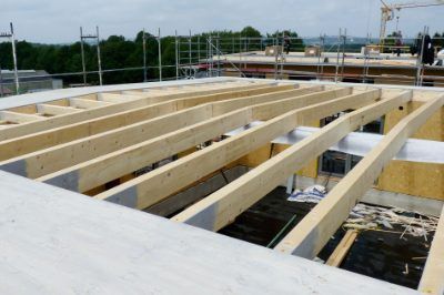 Zimmerei Zultner GmbH & CO. KG - Querbalken aus Holz über einem Rohbau