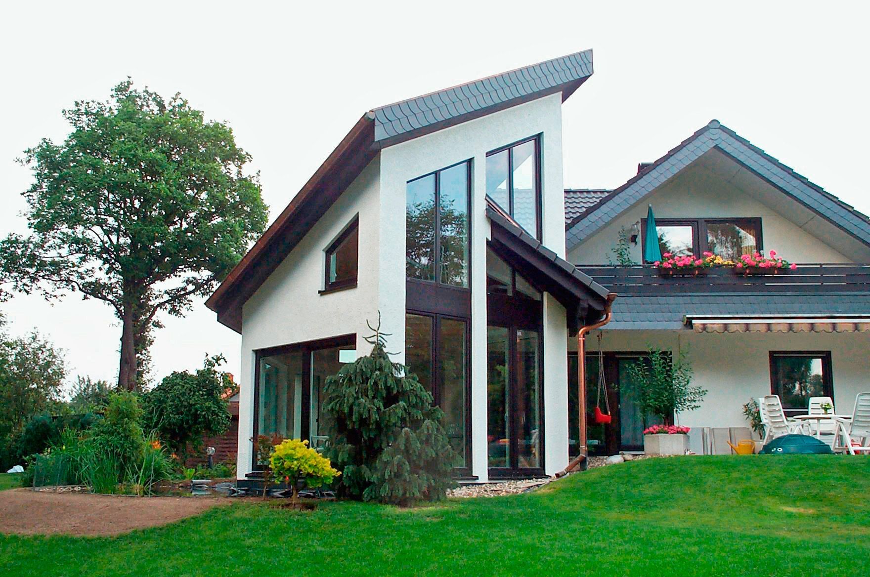 Zultner GmbH & CO. KG - Ein großes weißes Haus mit einem Baum davor