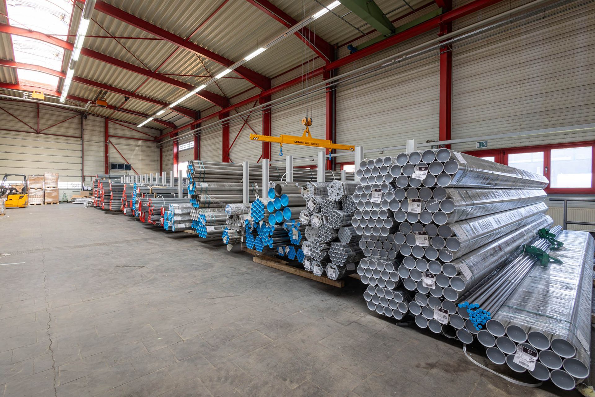 Eine Lagerhalle voller übereinander gestapelter Metallrohre.