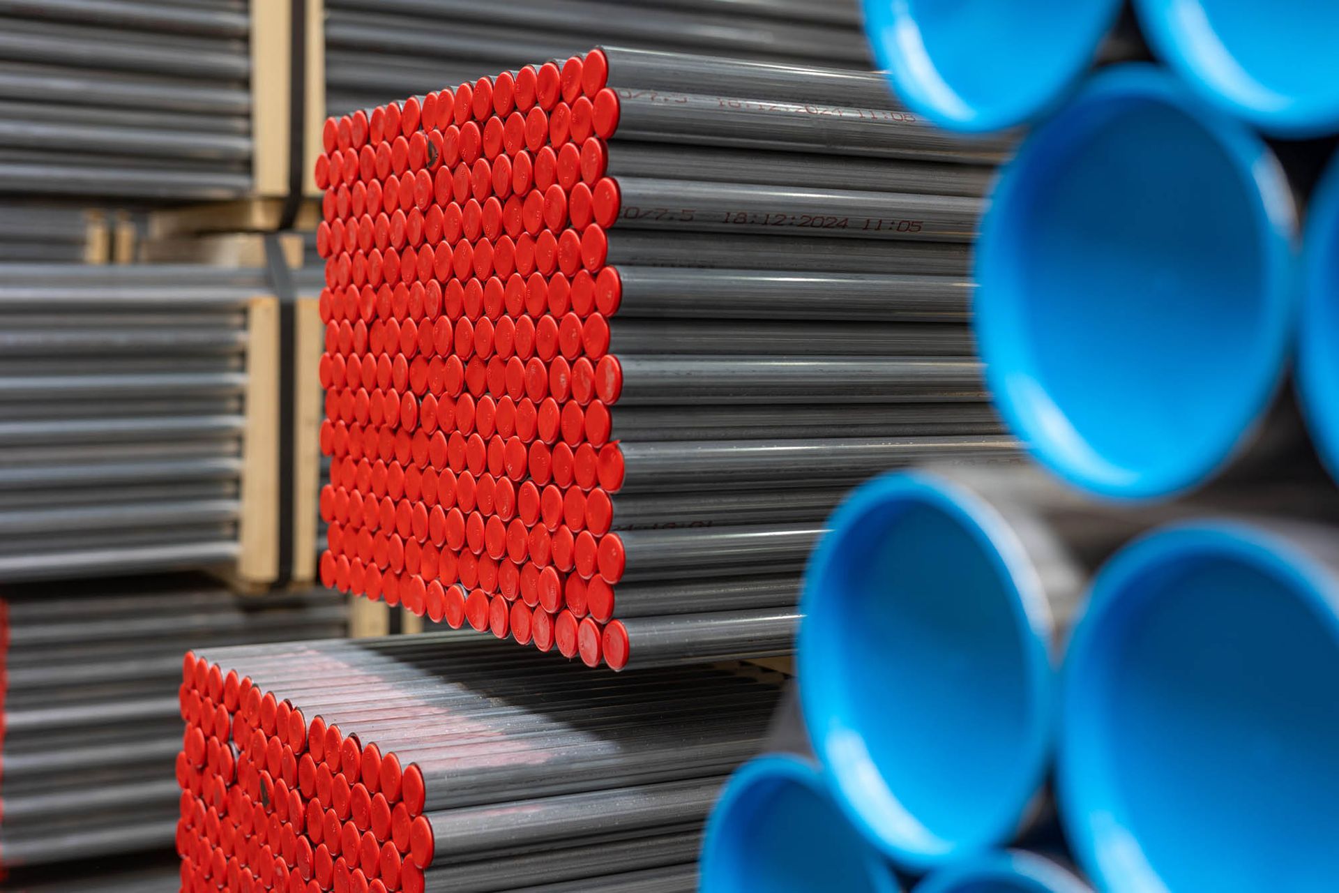 Ein Stapel blauer und roter Rohre, die übereinander liegen.