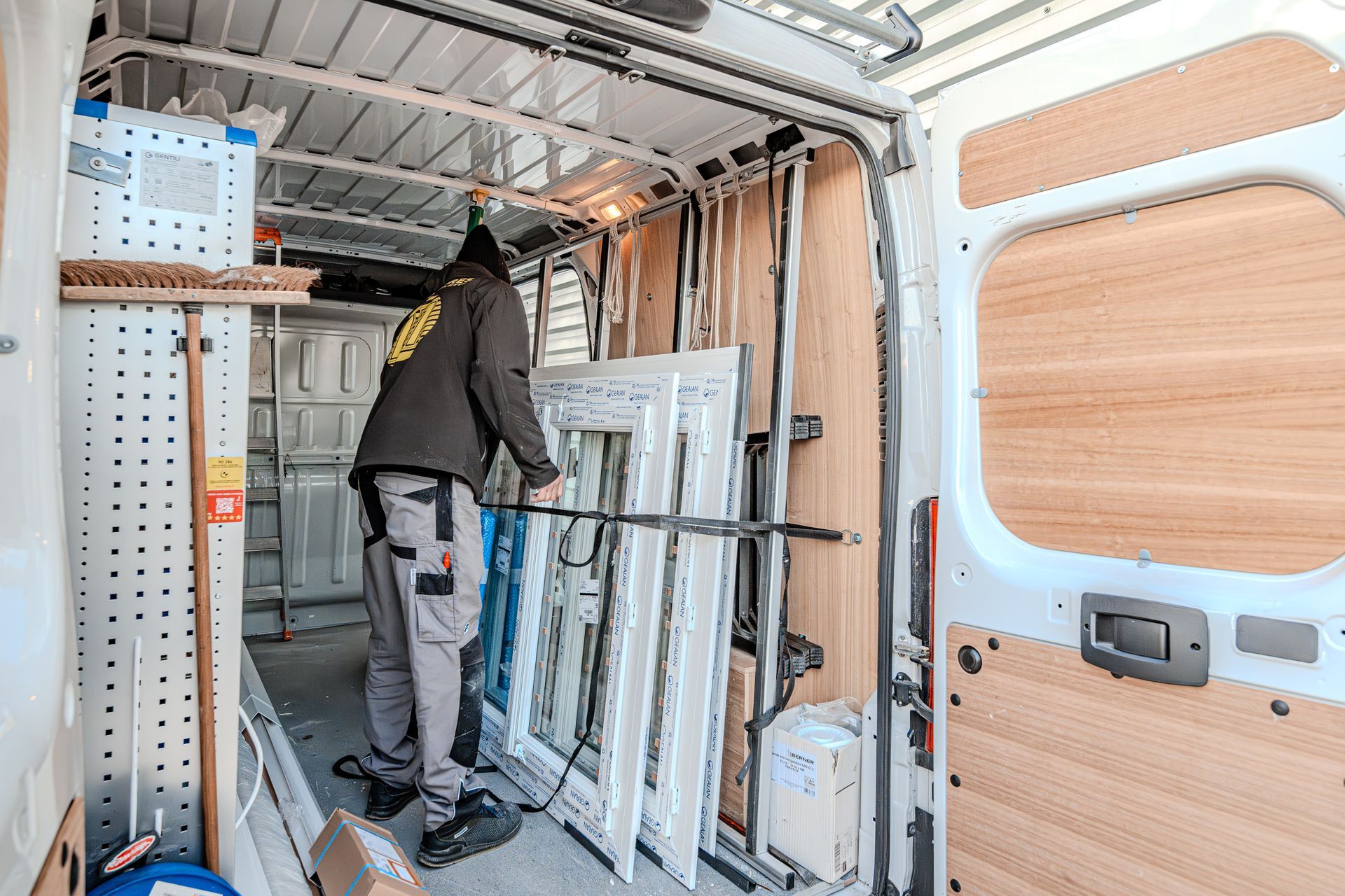 Homme dans un camion qui décharge des fenêtres.