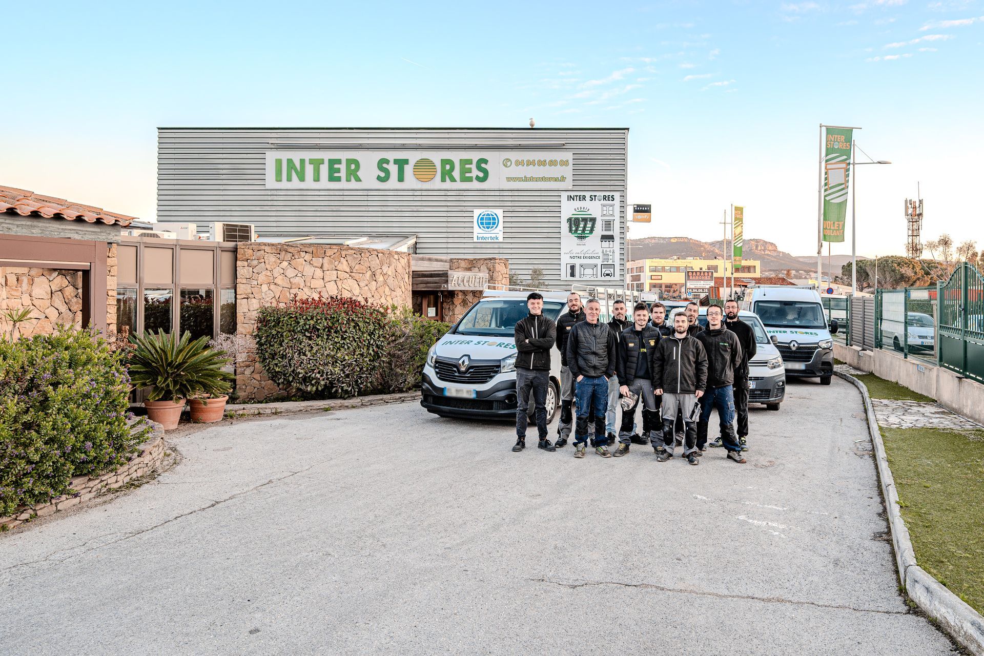 Équipe de l'entreprise d'Inter Stores devant le bâtiment.