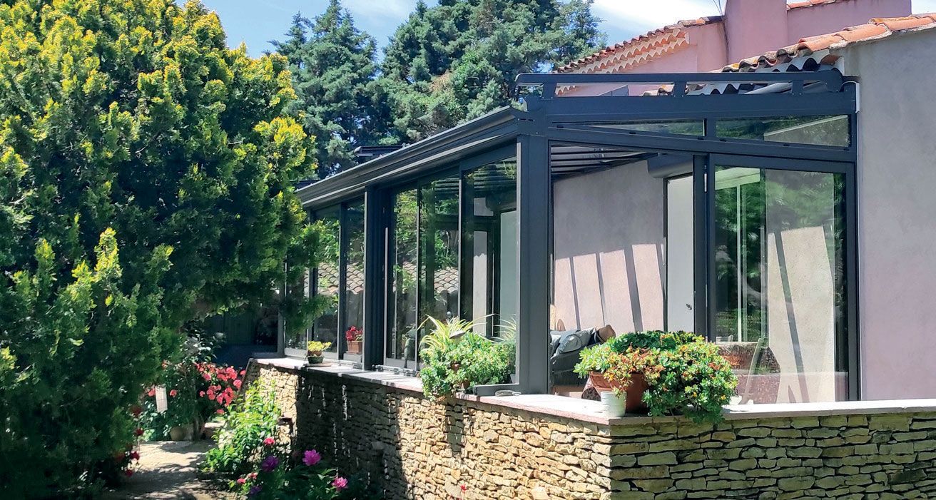 Intérieur d'une véranda avec salon de jardin et babyfoot.