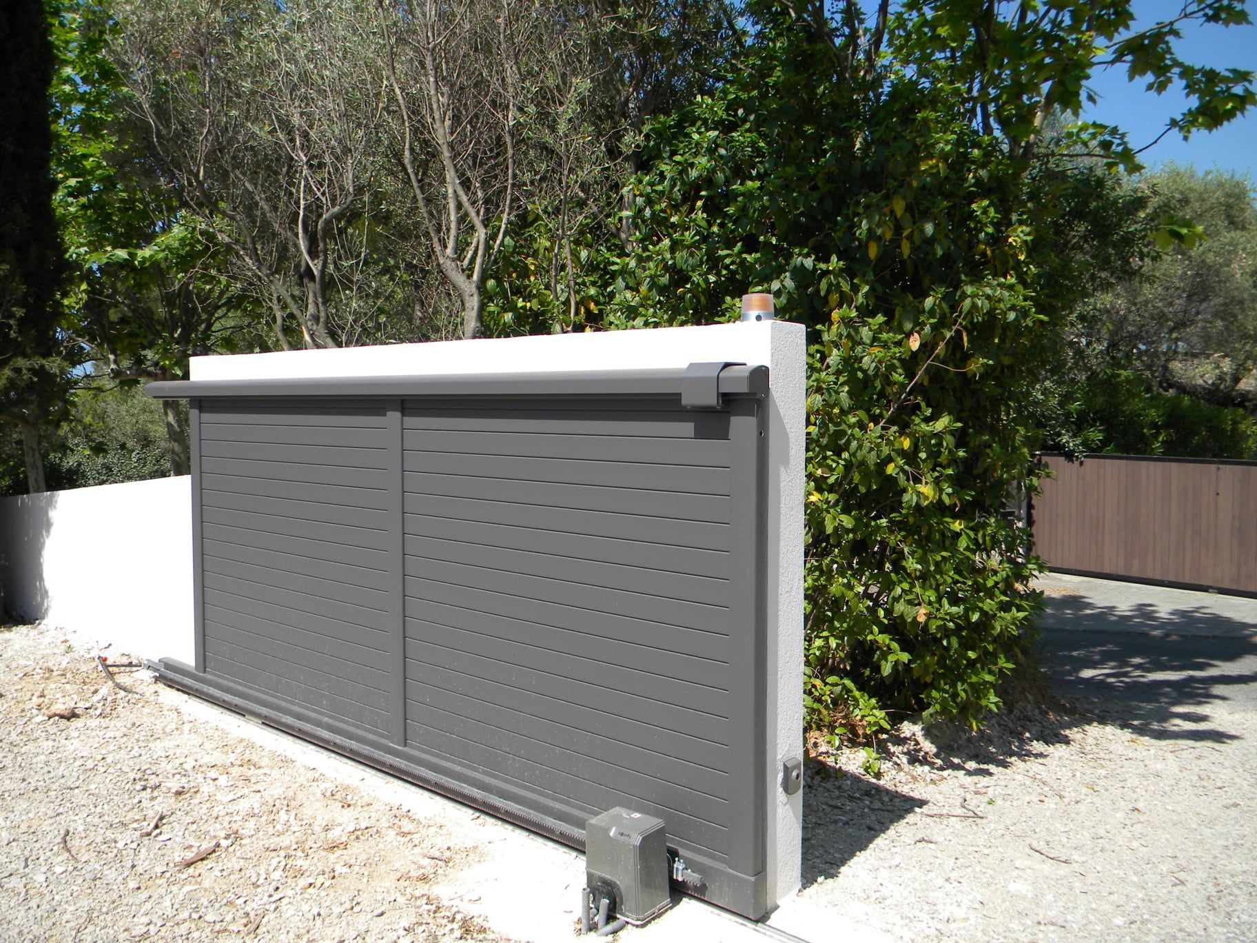 Portail motorisé gris.