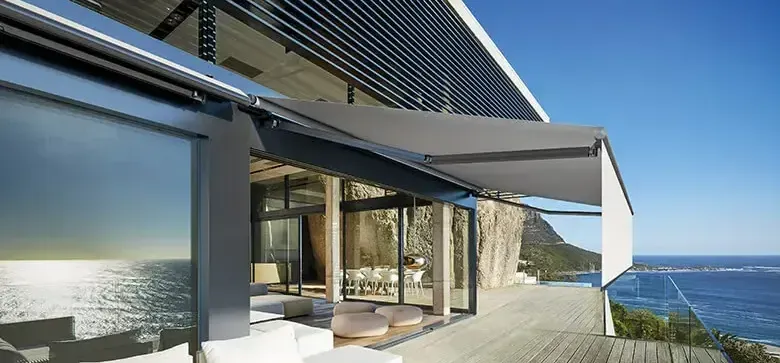 Bâtiment avec un store banne devant une plage.