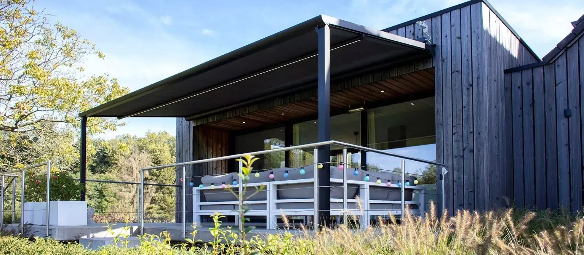 Pergola avec une toile noire sur une terrasse.
