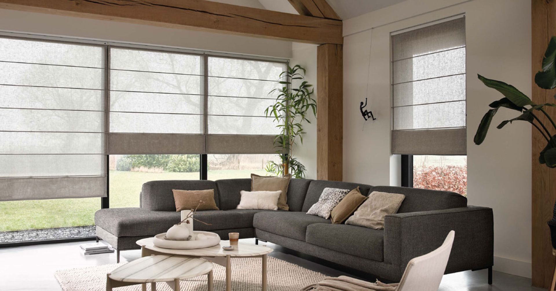 Salon avec grand canapé et stores.