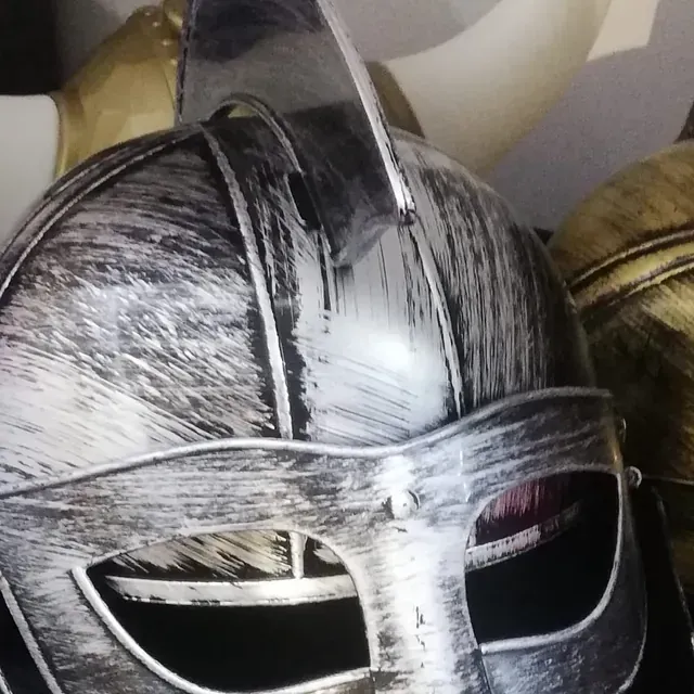 Un casco plateado con un cuerno en la parte superior.