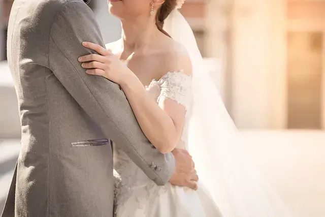 Una novia y un novio se abrazan y se besan el día de su boda.