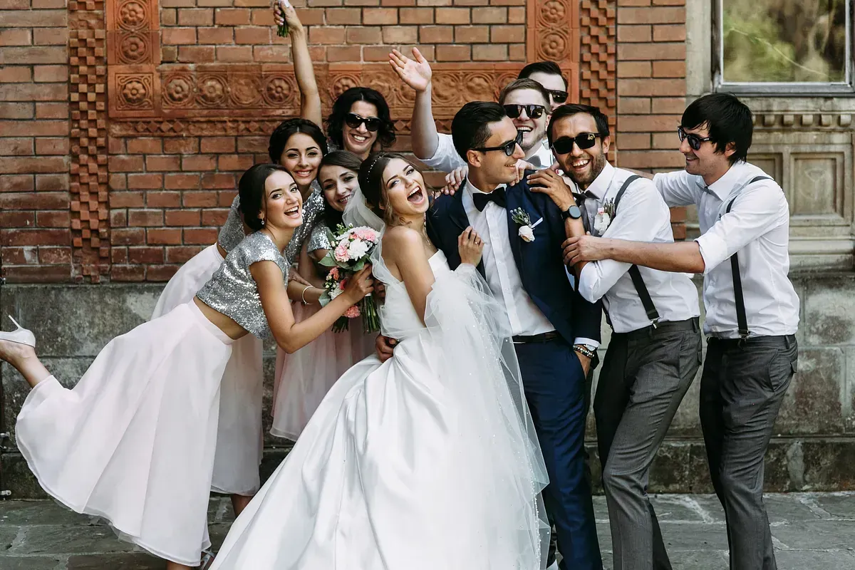 Una novia y un novio posan para una fotografía con su fiesta nupcial.