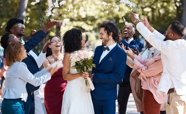 Una novia y un novio posan para una fotografía con su fiesta nupcial.