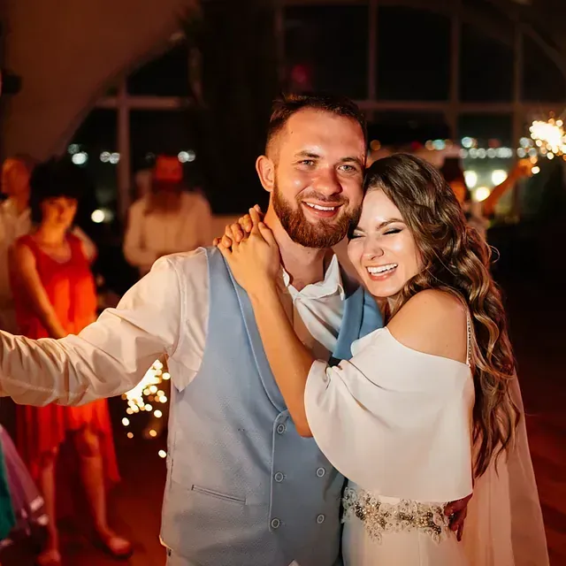 Una novia y un novio posan para una fotografía en la recepción de su boda.