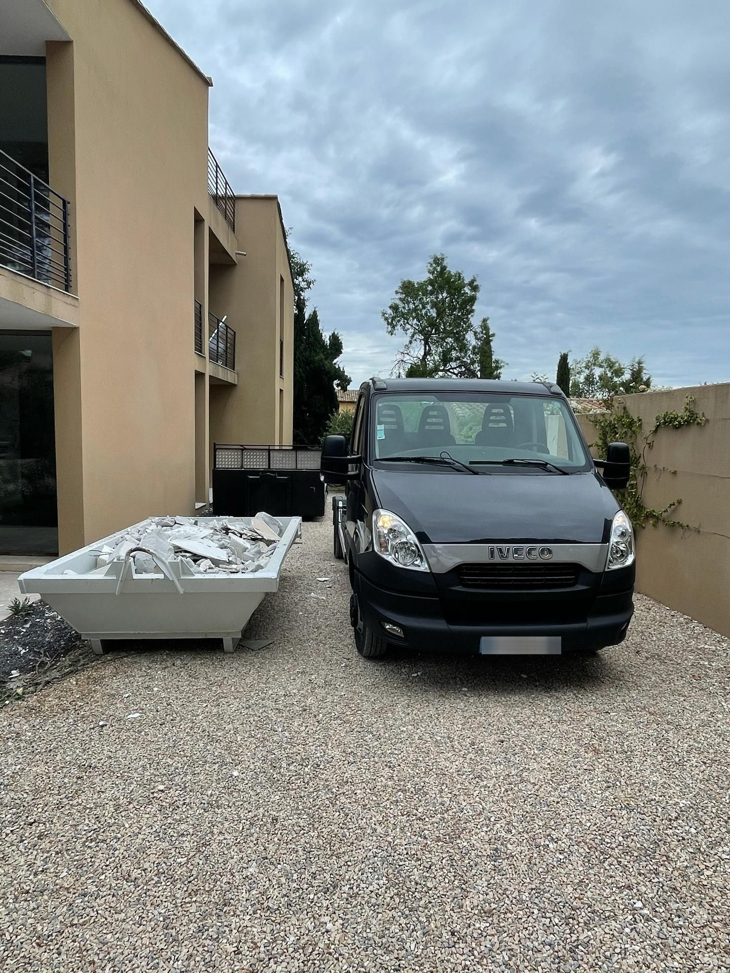 Camion à côté d'une benne de gravat