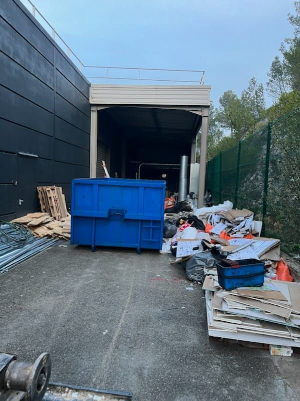 Une poubelle entourée de déchets près d'un quai de chargement