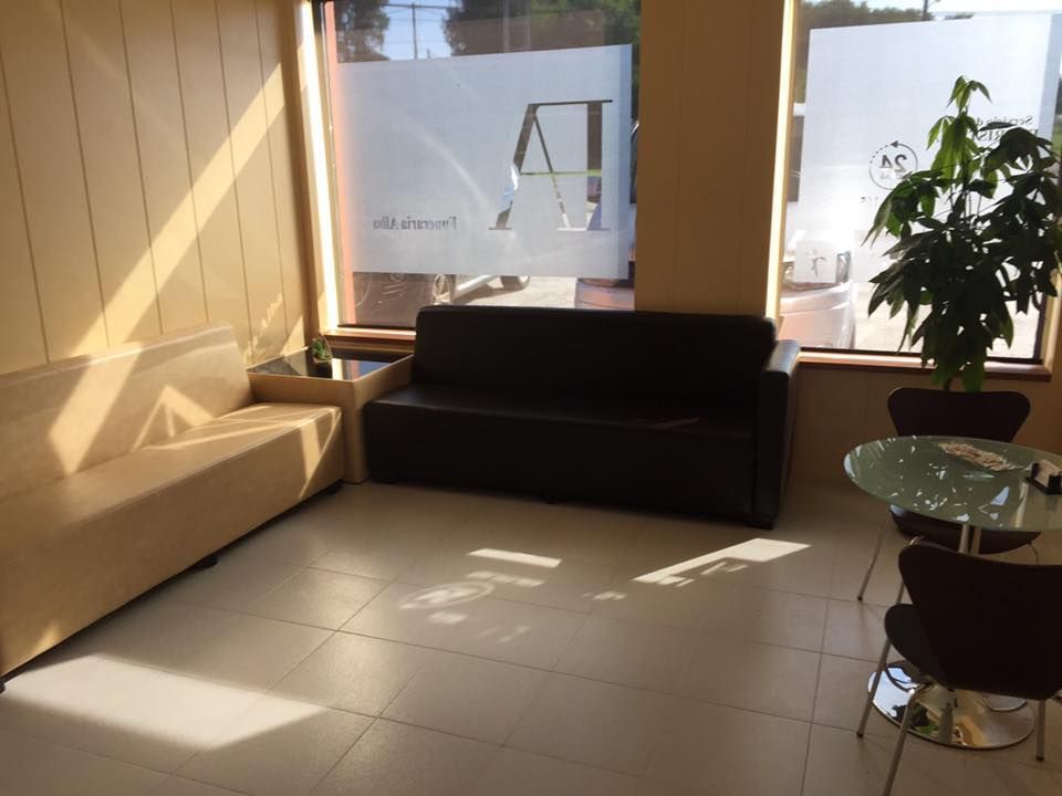 Una sala de espera con un sofá y una mesa