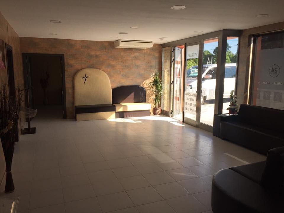 Una gran habitación vacía con un sofá y una cruz en la pared.