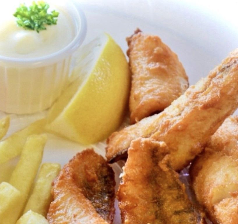 Un poisson est assis sur un morceau de papier avec des tranches de citron et des épinards.