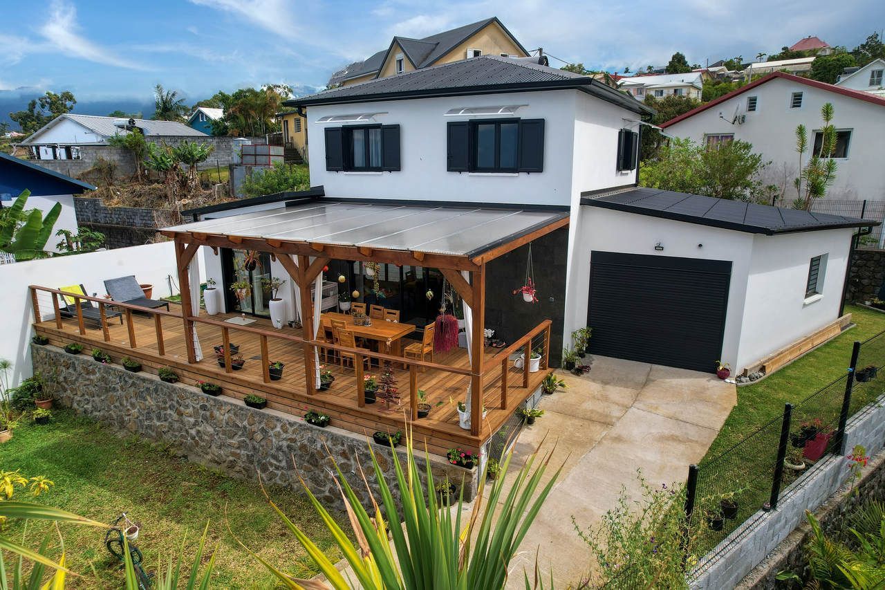 Grande maison avec une terrasse et une pergola