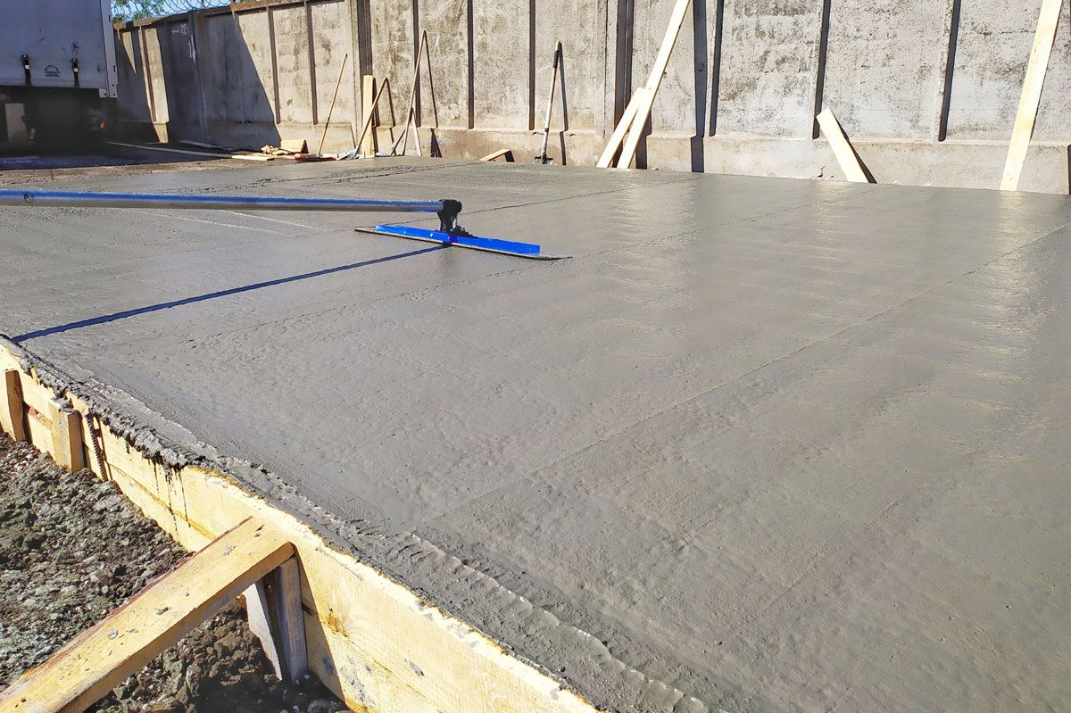 Professionnel lissant une chape de béton