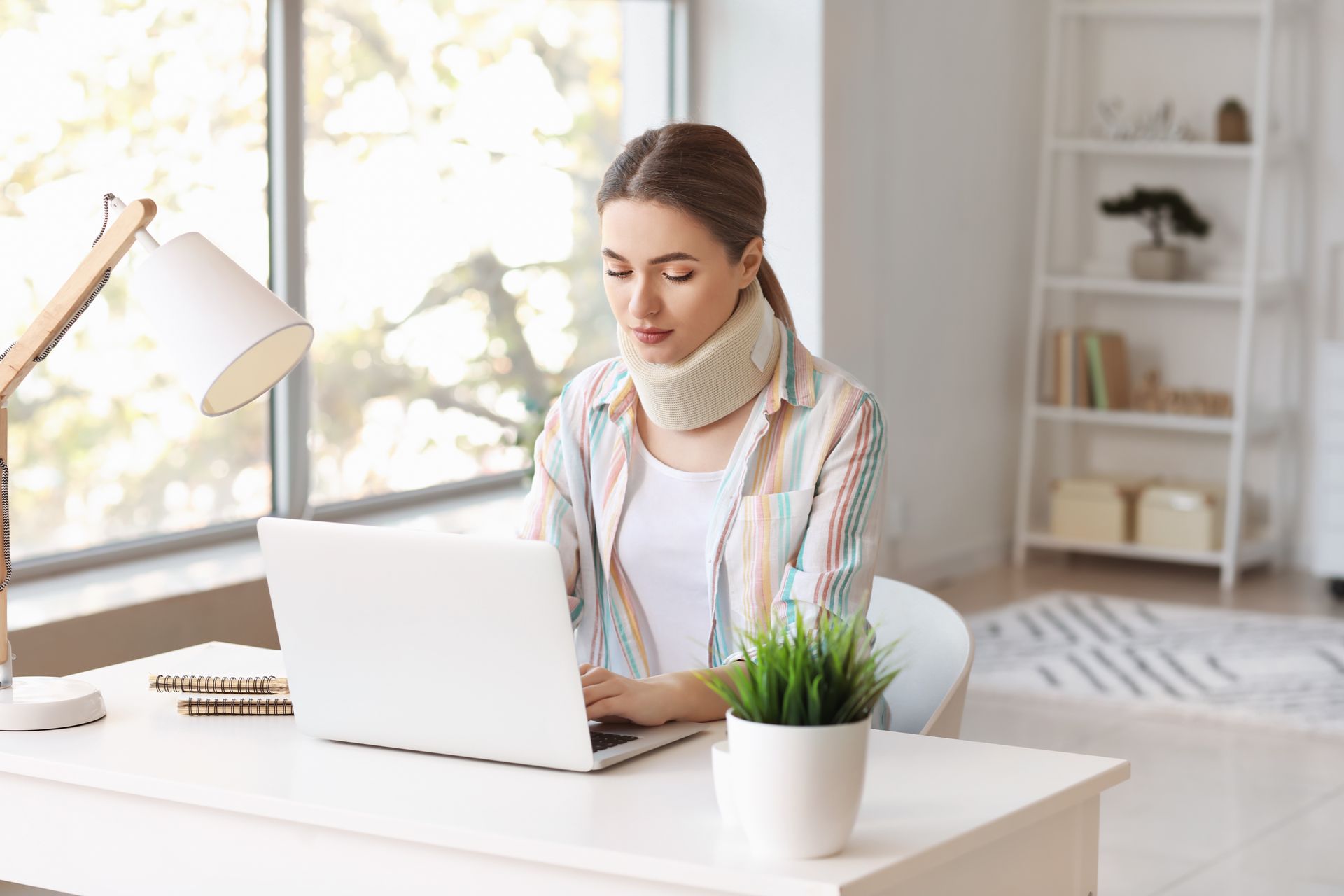 Femme devant PC avec une minerve