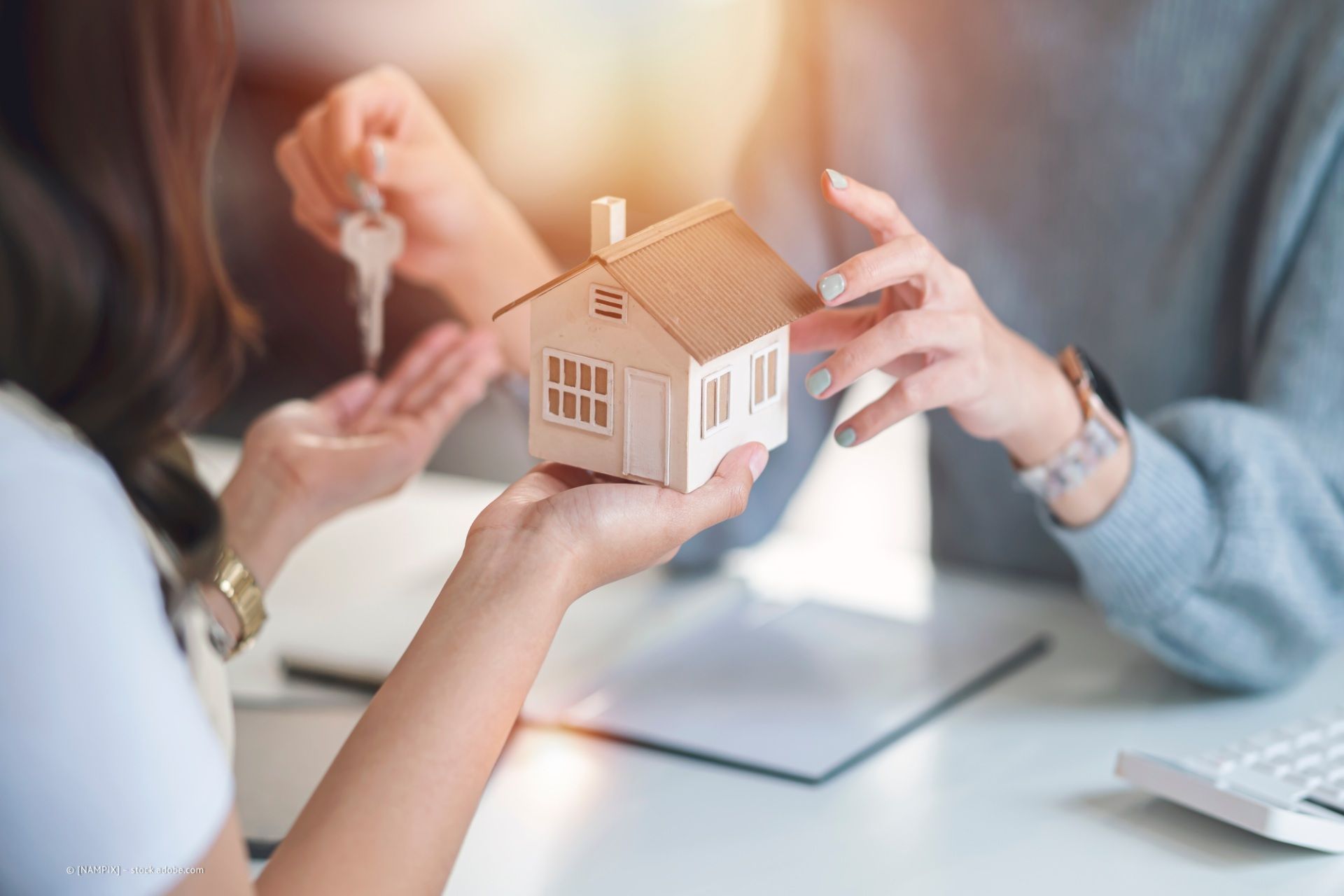 Personen zeigen auf Modellhäuser