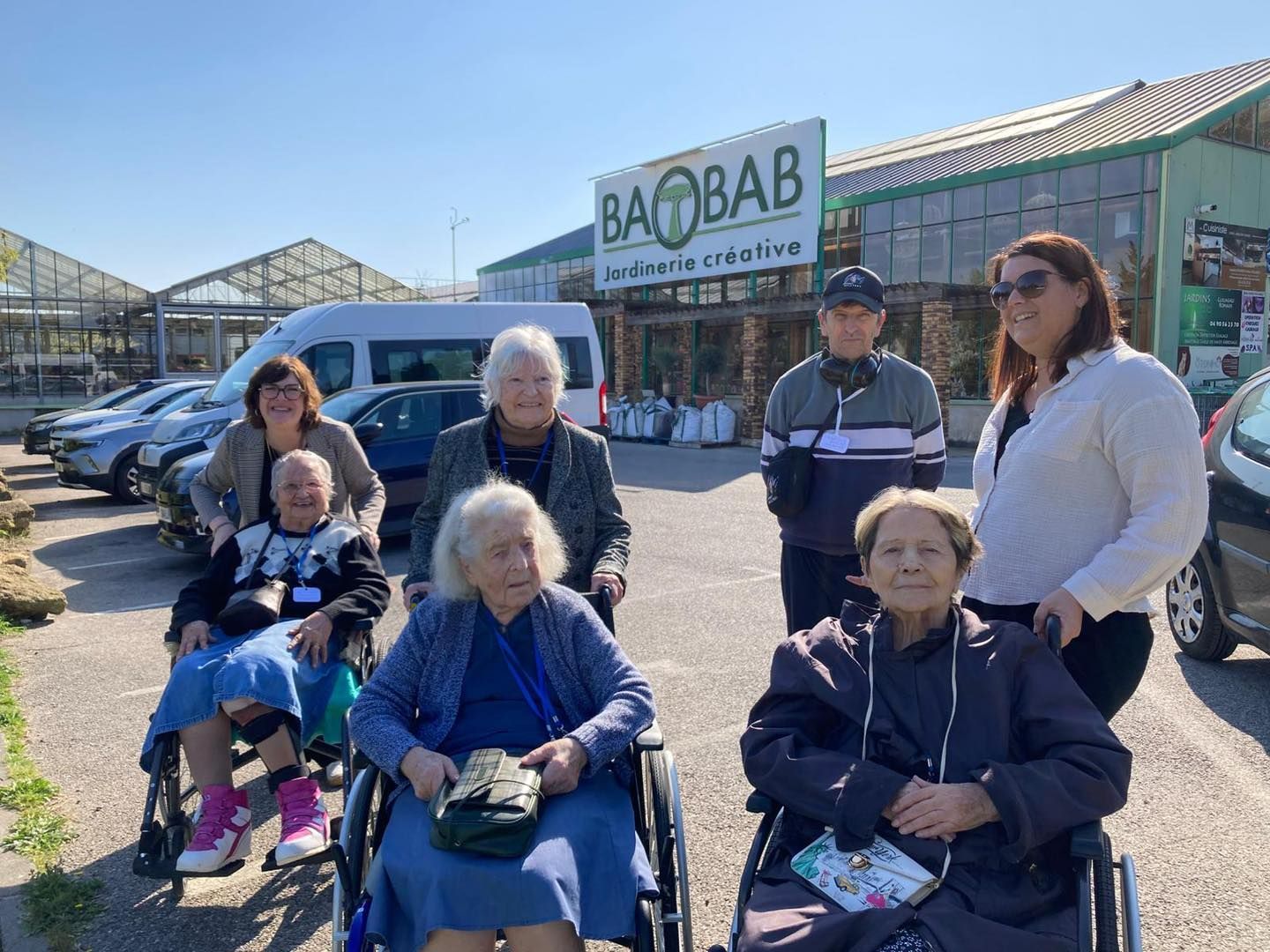Un groupe de personnes âgées, devant le centre de jardinage créatif Baobab.