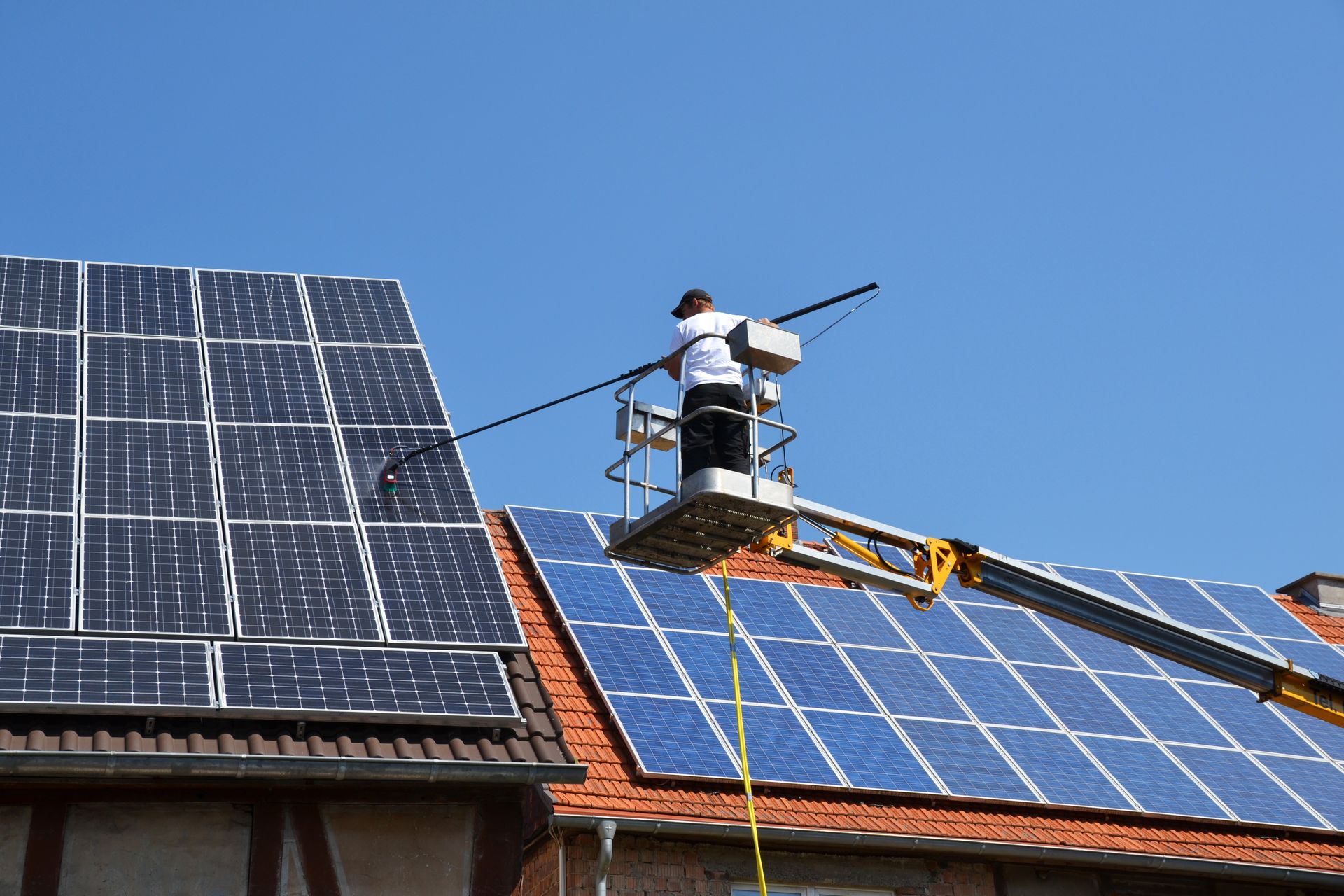 Reinigung von Solaranlagen auf Hausdach mit Teleskopstange