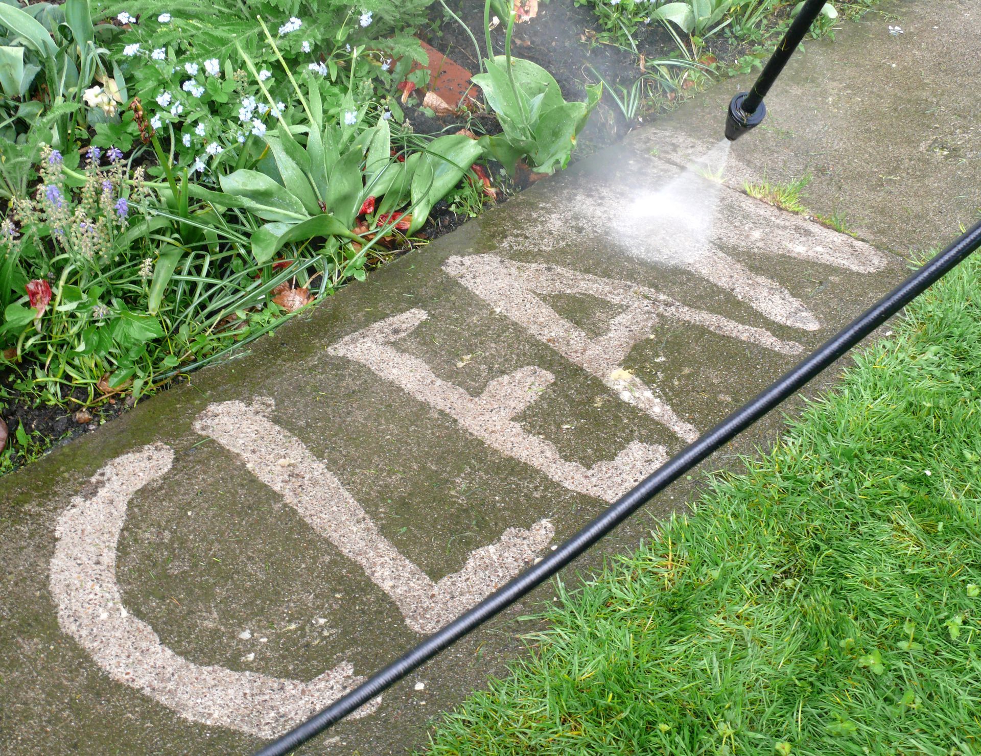 Reinigung einer Terrasse mit Hochdruckreiniger im Gartenbereich, Wort 