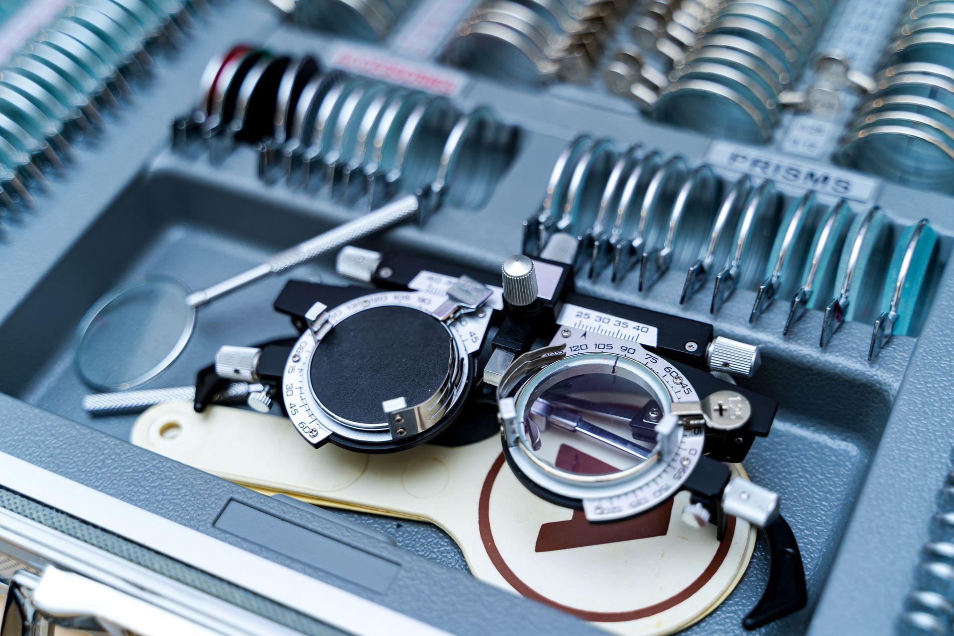 Kit d'essai de lentilles optométriques, comprenant une monture d'essai, des lentilles et des outils d'examen.