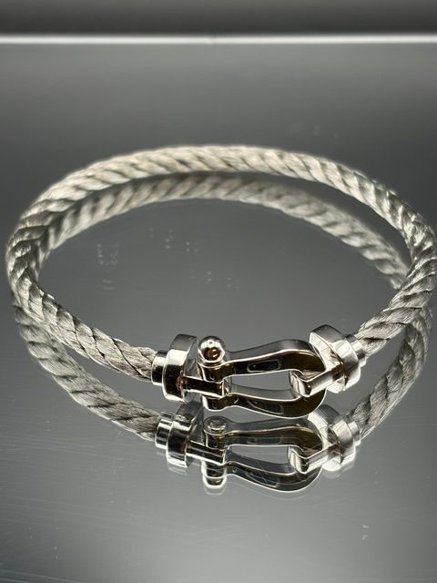 Montre-bracelet en or rose posée sur une table en bois avec un arrière-plan légèrement flou.