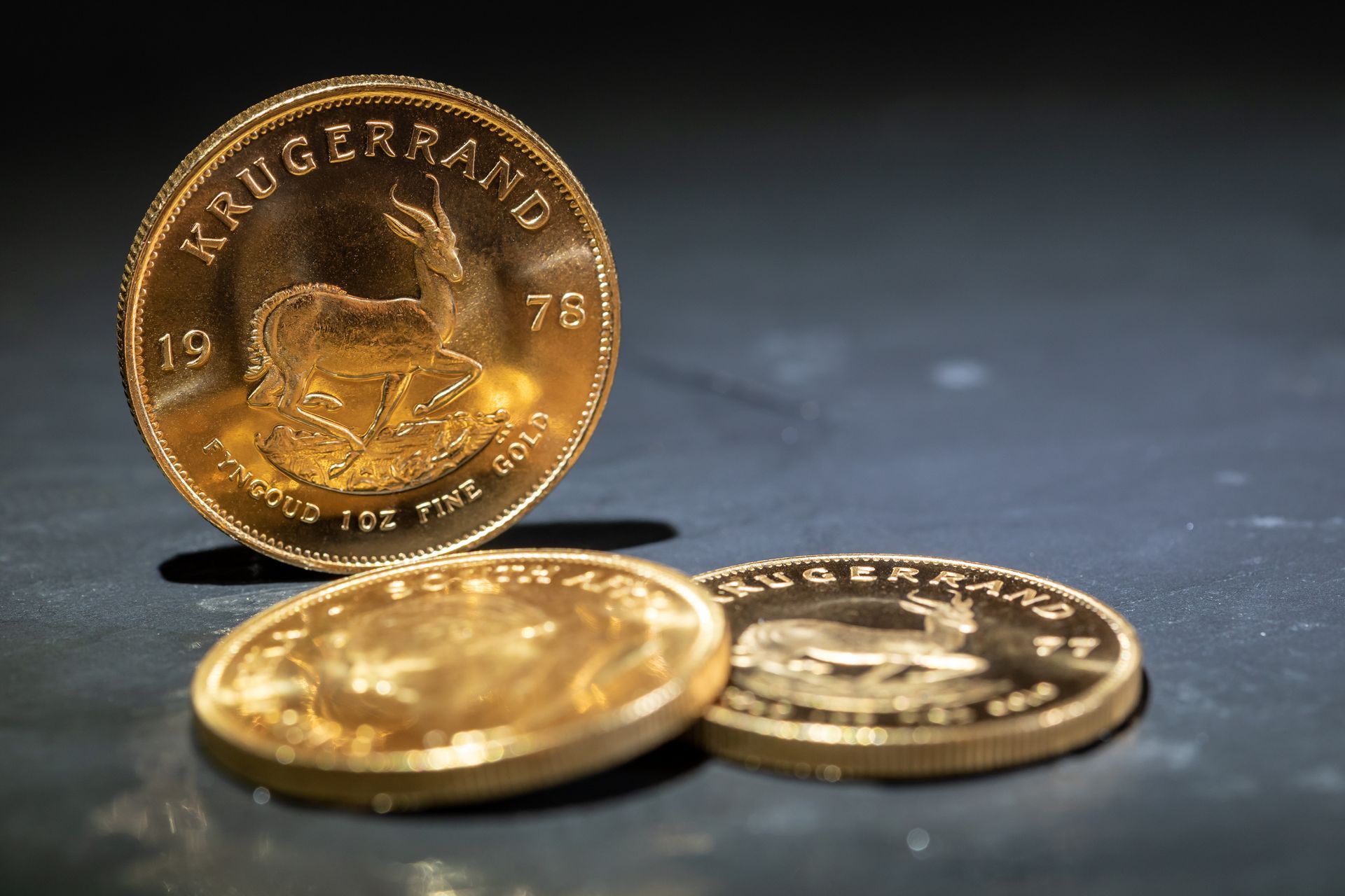 Pièces d'or Krugerrand sud-africaines empilées et posées sur une surface sombre