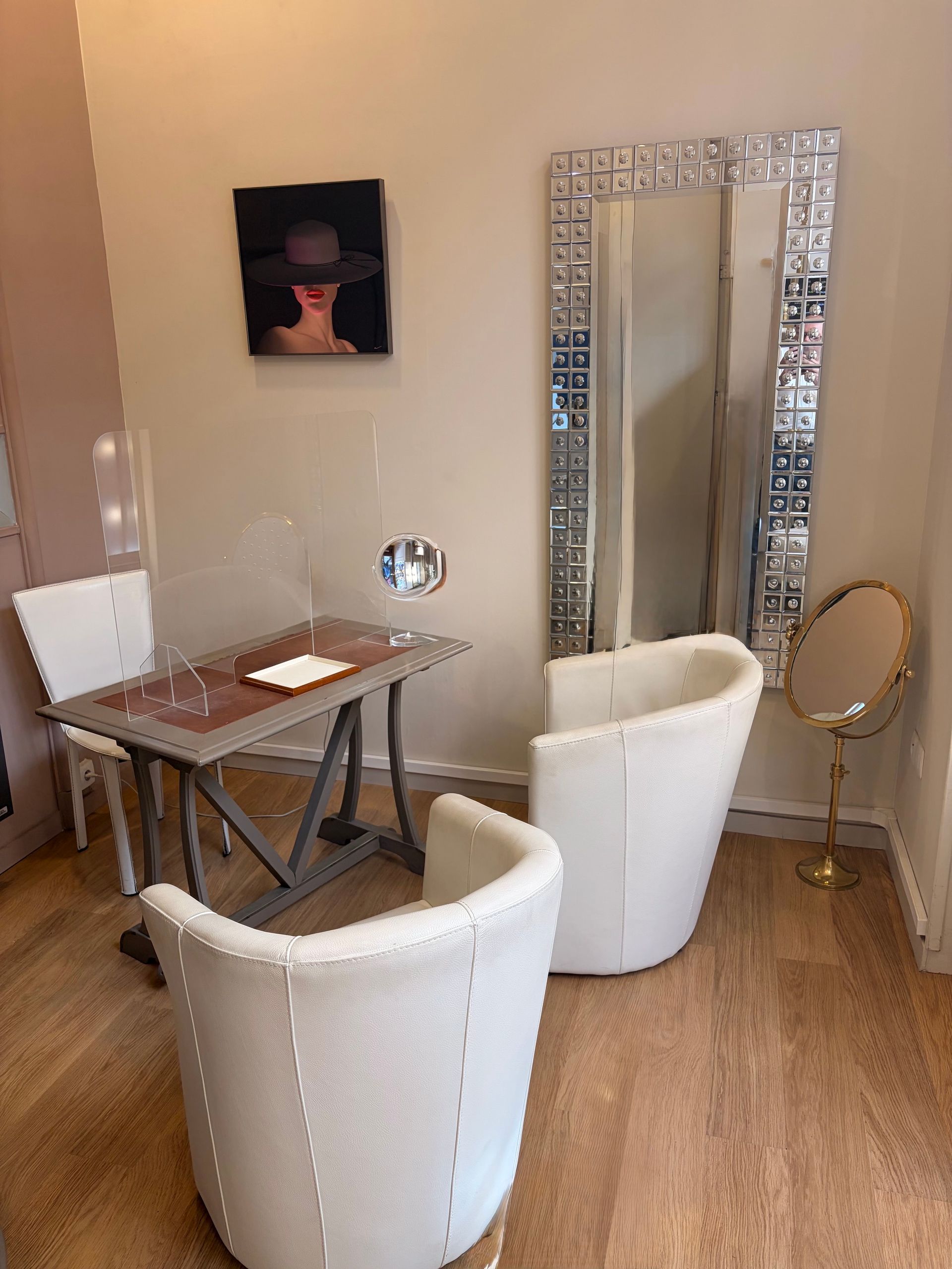 Bureau moderne avec deux chaises blanches et un grand miroir sur pied.