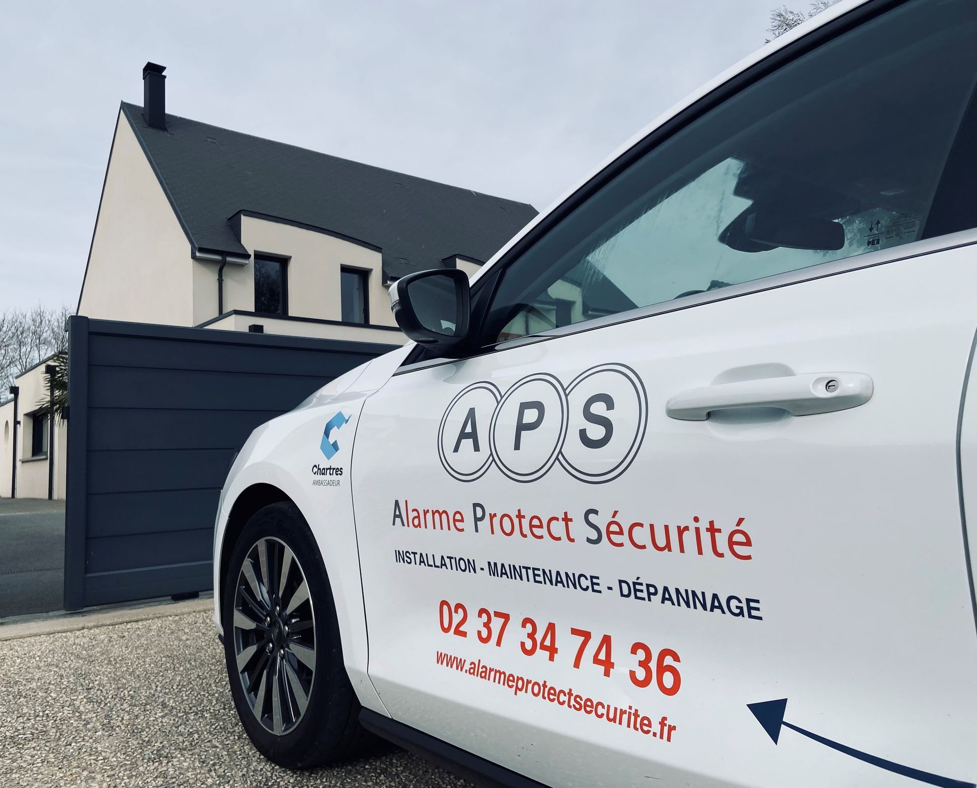 Une voiture blanche devant un portail