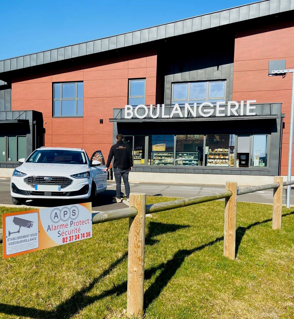 Un homme devant une enseigne de boulangerie